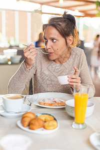 一位成年女性吃早餐的垂直形象图片