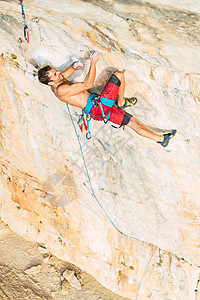 一位攀岩者双手和双脚握在岩石上的空中景象图片