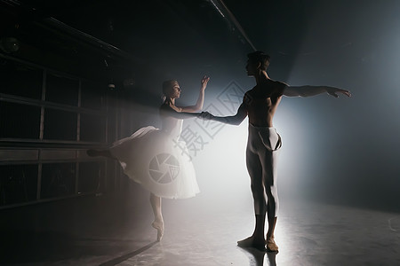 专业的芭蕾舞情侣在大舞台上的聚光灯下跳舞 泛光灯背景下的美丽年轻女子和男子 情感二重唱表演舞蹈艺术夫妻平衡工作室女士演员优美艺术图片
