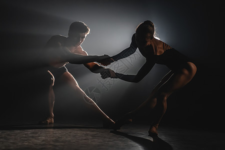 泛光灯背景下美丽的年轻杂技演员或体操运动员 专业的芭蕾舞情侣在大舞台上的聚光灯下跳舞 情感二重唱表演编舞艺术优美艺术家男人成人幸图片
