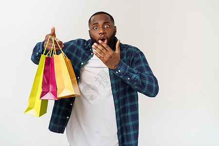 非洲快乐的美国人在白色背景上拿着购物袋 享受节日概念商业购物可用男人横幅女性成人购物者顾客销售图片