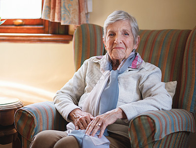 快乐的年长妇女坐在沙发上微笑 在家享受退休生活头发女士个性情感老年灰色学习眼镜图书图书馆图片