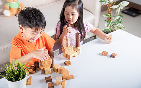 男童和女童玩木制建筑工木块建筑的游戏桌子女孩字母学校幼儿园男生闲暇生活家庭童年图片