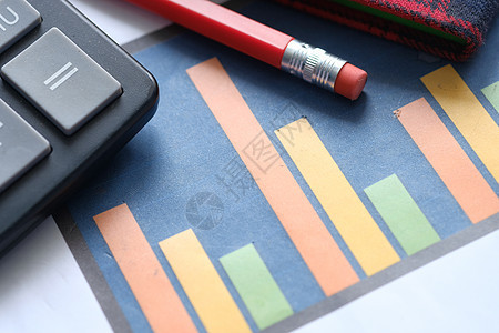 表格上的财务图表 计算器和注纸报告金融记事本条形工作红色文档文书商业铅笔背景图片