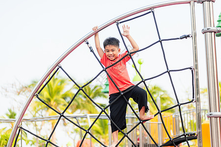 亚裔儿童笑着玩攀爬户外游乐场蹦床运动幸福友谊喜悦丛林公园院子梯子托儿所图片