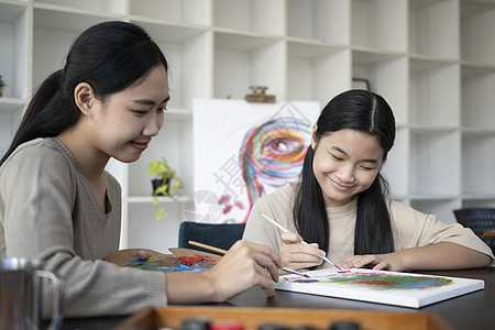 在艺术课上 在画布上微笑的亚洲女孩绘画图片