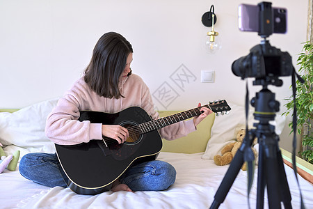 青少年女孩弹奏音乐吉他 频道录制录像 博客播客玩家音乐家房间教学视频居住博主互联网微笑图片
