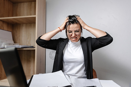 工作压力 办公室里的女工愤怒而沮丧地低着头 压力在办公室 气氛不好 生活在一份新工作的非办公室概念中 混合工作图片