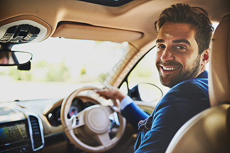 在上班前以微笑开始您的早晨 一个性格开朗的年轻商务人士的画像 他开车上班 坐在车流中 看着镜头图片