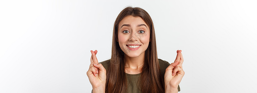 特写肖像希望美丽的女人交叉她的手指 睁开眼睛 希望 问最好孤立在灰色的墙壁背景上头发成人女孩学生幸福快乐白色微笑手势女士图片