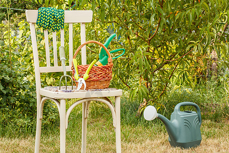 在自然背景的旧椅子上 装有威克篮子和花园工具柳条植物乐器实施手套硬件工作绿色培育喷壶图片