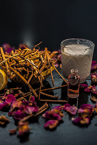黑色木质表面上的 manjistha 或印度茜草根面罩 由 manjistha 根粉 柠檬 牛奶和一些必需的玫瑰油组成 用于轻微背景图片