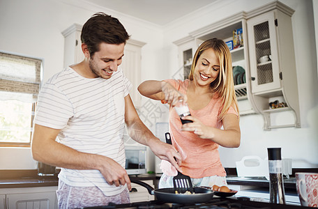 共享早餐会更好 一对快乐的年轻夫妇在家里一起做早餐图片