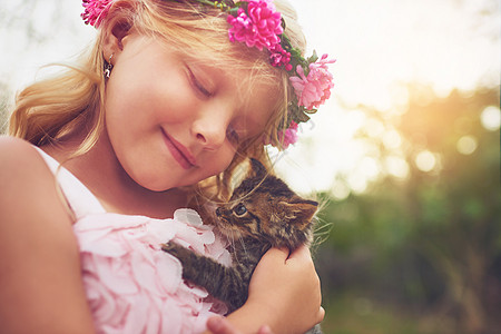 我的毛皮朋友 一个快乐的小女孩 抱着一只小猫笑着坐在自然界外边图片