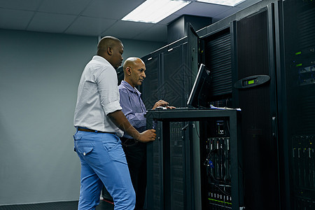 系统管理员来救援 两名 IT 技术人员在数据中心工作时使用计算机图片