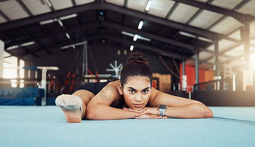 女人在健身房的地板上伸展 在体育俱乐部做锻炼和健身训练 运动员或体操运动员在地板上做体操 健康和身体瑜伽的肖像图片