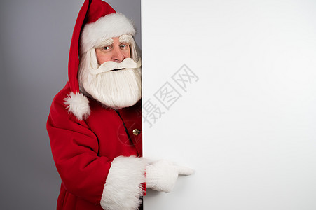 圣诞老人在白背景广告后面偷看 圣诞快乐 圣诞快乐男性祖父戏服手套卡片喜悦海报礼物男人横幅图片