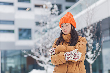 在街头的亚洲女人 冷冻在寒冷中 在一个冬天雪天 等待着街道成人蒸汽女孩呼吸加热夹克城市女性外套图片