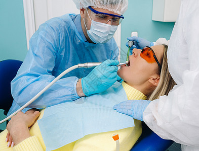 一位带牙科工具的男牙医与助手一起为病人钻牙 医学 牙科和医疗保健的概念微笑牙齿职场款待椅子外科演习口腔女孩办公室图片