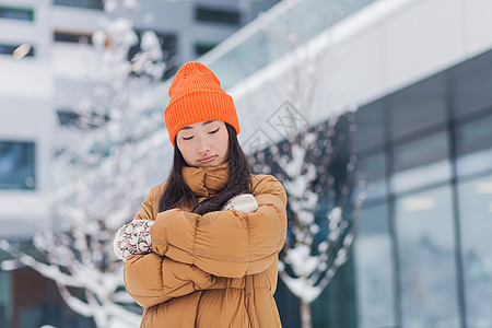 在街头的亚洲女人 冷冻在寒冷中 在一个冬天雪天 等待着气候外套毛衣成人衣服冻结女性世界呼吸女孩图片