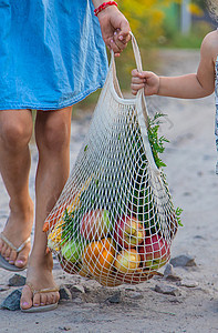 孩子们带蔬菜在袋子里 有选择的焦点微笑食物女儿顾客面包购物市场家庭消费者店铺图片