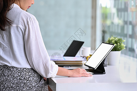商业女商务人士坐在明亮的办公室里 用电脑平板电脑工作图片