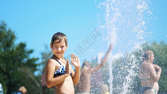 快乐的八岁穿泳衣的女孩在街头城市喷泉 户外 公园 夏日 阳光炎热的假期中玩得开心活动太阳家庭童年女性假期幸福飞溅花园行动图片