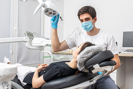 牙医在牙科诊所调整牙科灯 牙医在治疗前打开灯工具病人外科专家医院医生设备访问手术矫正图片