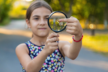 小孩在公园学习蜗牛 有选择地集中注意力女孩男生孩子玻璃花园镜片放大镜童年乐趣生物学图片