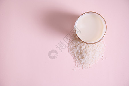 粉红背景的新鲜有机 原始素食和蔬菜大米牛奶杯子 配有复制广告空间图片