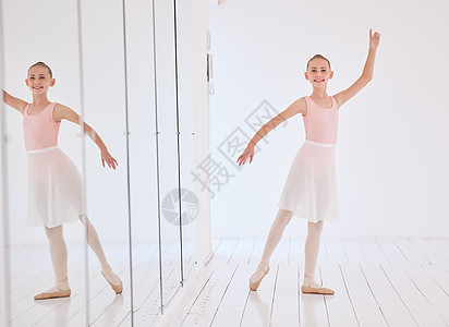 快乐的芭蕾舞演员女孩在有镜子反射和肖像的舞蹈室里伸展身体 一个学习的孩子在课堂上穿着粉红色公主服装跳舞表演的笑脸图片