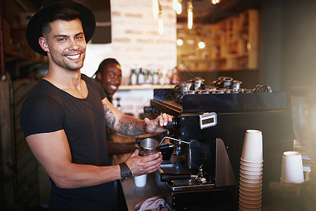那你还没有喝到最好的咖啡 一个在咖啡馆里操作咖啡机的年轻人图片