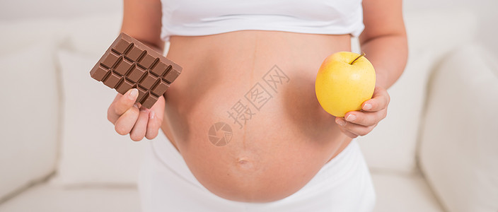 怀孕妇女持有苹果和巧克力 怀孕九个月就已经是第九个月了女孩食物生活饮食水果工作室妈妈腹部酒吧女性图片
