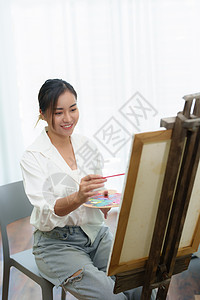 一个亚洲女人在闲暇时间设计艺术的肖像技术画架休闲快乐学习孩子电脑成人摄影老师图片