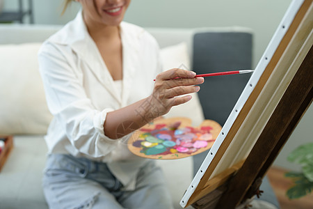 一个亚洲女人在闲暇时间设计艺术的肖像老师动机抽屉画笔热情画架课堂教育技术职业图片