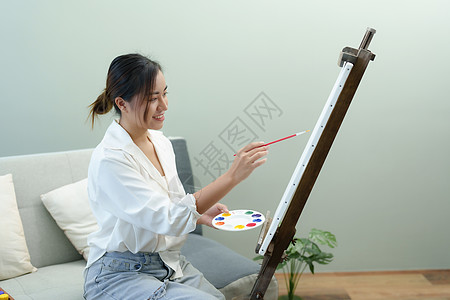 一个亚洲女人在闲暇时间设计艺术的肖像学生摄影材料休闲画架教育创造力职业热情画家图片