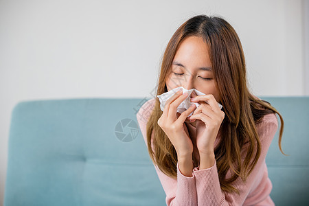 在沙发上坐着被毯子覆盖着的亚洲年轻女青年病人药店季节发烧喷嚏女性组织保险女士卫生图片