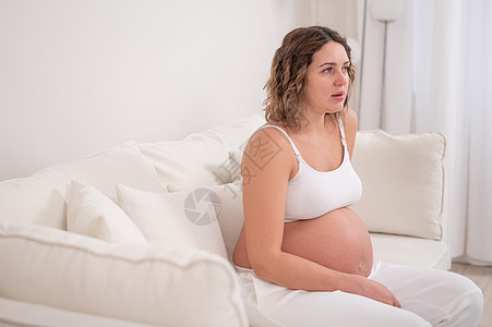 孕妇在白沙发上坐着很累图片