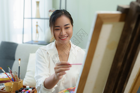 一个亚洲女人在闲暇时间设计艺术的肖像作坊老师职业成人学习学生摄影画架服装快乐图片