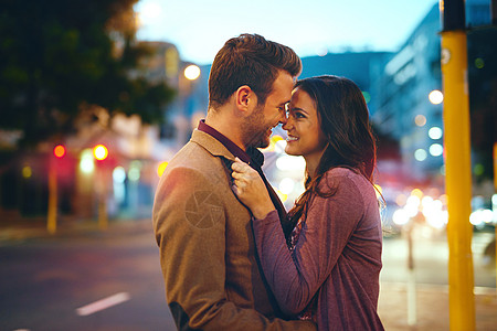 疯狂地 深沉地和真正地坠入爱河中 一个亲情的年轻夫妇在城里约会时接吻图片