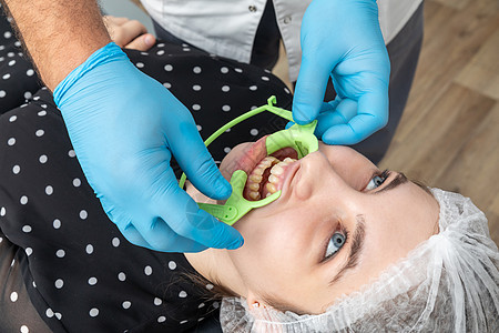 安装牙科牙医 在牙科办公室为一名病人安装耳脸切除器图片