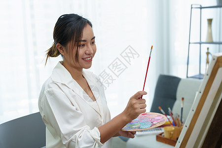 一个亚洲女人在闲暇时间设计艺术的肖像休闲动机青少年老师画家课堂运动服装摄影热情图片