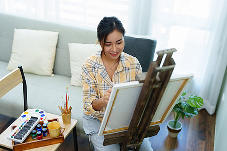 一个亚洲女人在闲暇时间设计艺术的肖像成人画架大学课堂画家休闲技术学生教育画笔图片