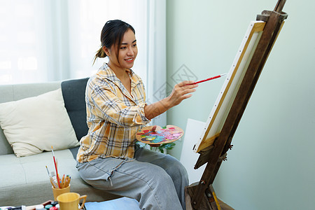 一个亚洲女人在闲暇时间设计艺术的肖像学习技术商业青少年画架画笔摄影材料孩子想像力图片