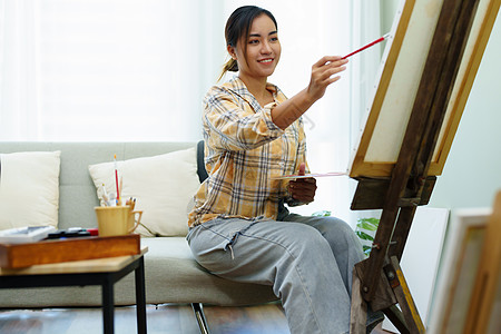一个亚洲女人在闲暇时间设计艺术的肖像画架商业材料想像力服装作坊职业休闲电脑创造力图片