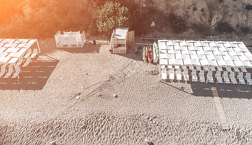 海滩上的天篷下空荡荡的躺椅 海滩区是空的 没有人 遮阳罩下的白色塑料日光浴床 假期结束 假期开始 等待游客太阳海岸甲板天堂休息室图片