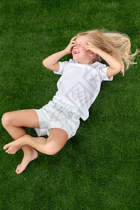 金发美女 闭着眼睛躺在绿草上 蒙上白色T衬衫 顶级风景图片