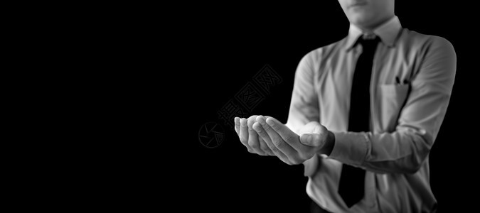 身着蓝色衬衫的黑领带和双手 内装着黑色背景隔绝的东西 在照片中拍摄到一个无法辨认的男人小吃皮肤白色平衡身体棕榈手臂测量男性手指图片