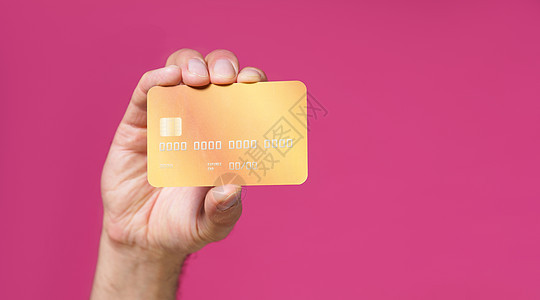 紧紧的黄色借记 人手信用卡与粉红背景隔绝 金融 银行概念 没有脸部可见图片