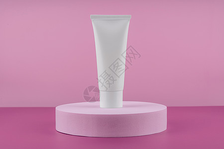 在讲台上用粉红色背景的台阶上展示化妆品白管子 奶油瓶 润滑剂 慕斯护肤常规示范品 美容清洁工 洗发水站图片